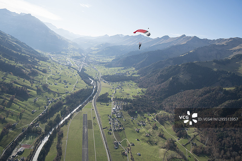 翼装飞行者翱翔于群山之上图片素材