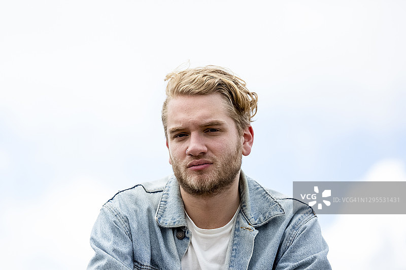 20岁青年正面肖像，天空背景，留有文案空间图片素材