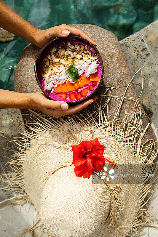 女人在游泳池边手拿冰沙碗图片素材