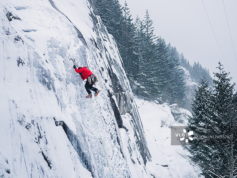 暴风雪中，攀冰者在加拿大不列颠哥伦比亚省斯阔米什攀登冰壁图片素材