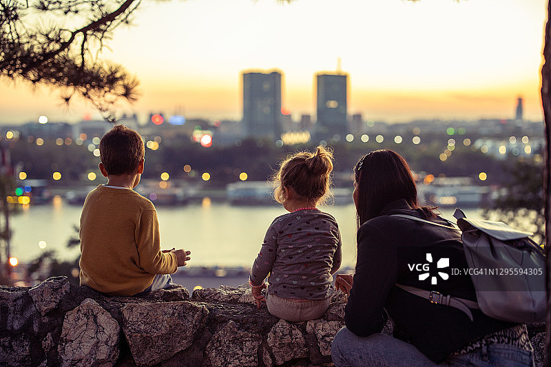 母亲与两个孩子在观景点欣赏城市风光图片素材