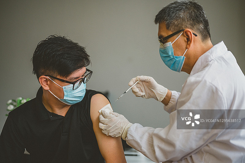 亚洲男子准备接种新冠疫苗图片素材