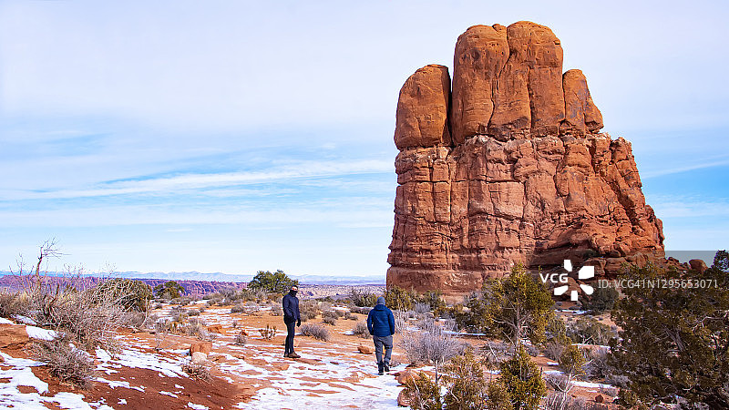 冬季在犹他州拱门国家公园徒步旅行的两名男子图片素材