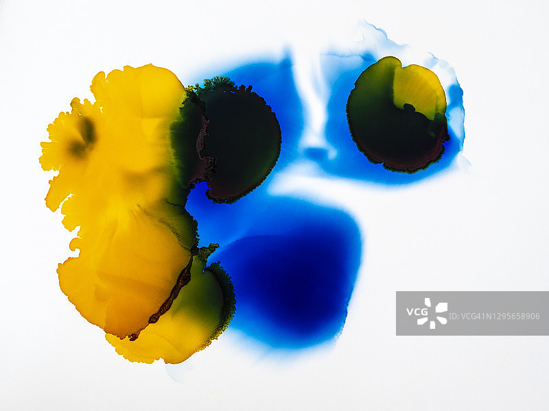 抽象背景，白色画布上的蓝黄色颜料滴图片素材