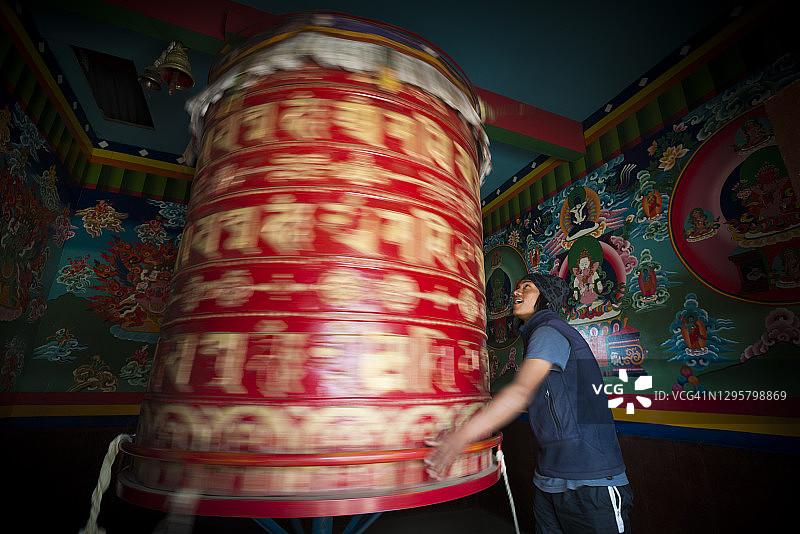 尼泊尔珠穆朗玛峰地区，一名尼泊尔男子在唐波切寺转动祈祷轮图片素材