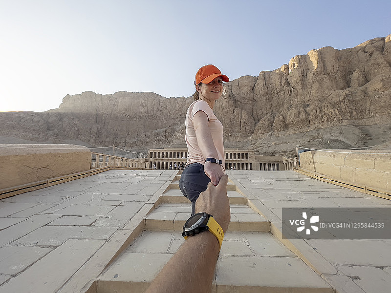 年轻女子在埃及哈特谢普苏特神庙牵着某人的手的场景图片素材