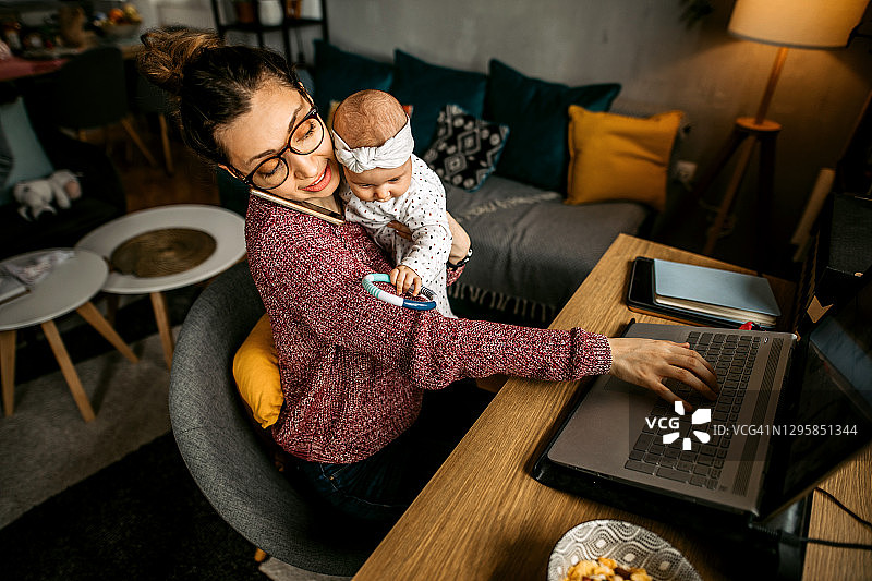 一边打电话一边做多项任务的母亲图片素材