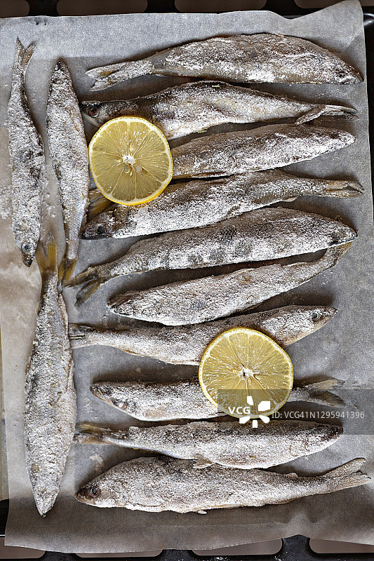 羊皮纸上的腌制全鱼和柠檬片图片素材