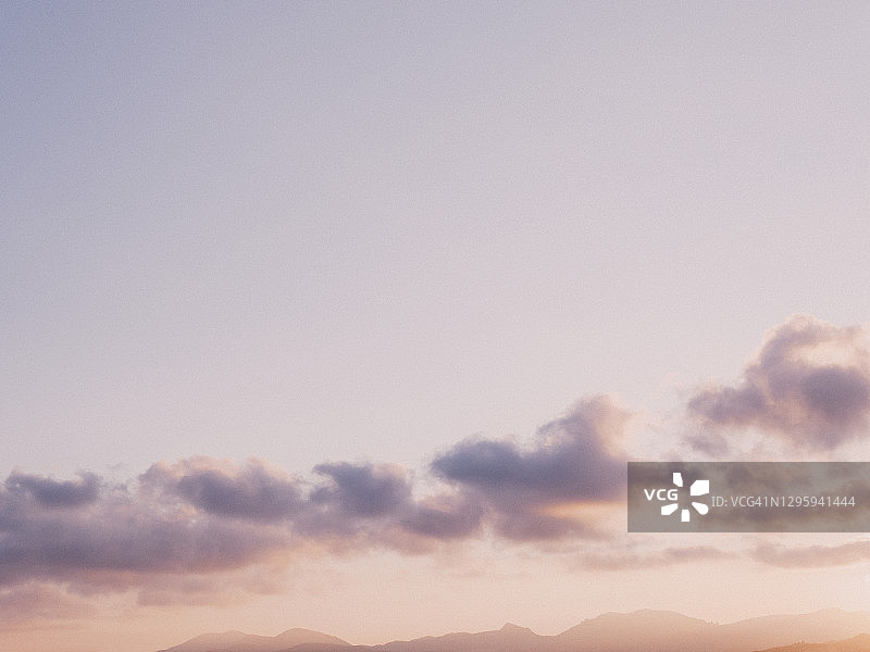宁静的日落天空中的淡紫色和云彩图片素材