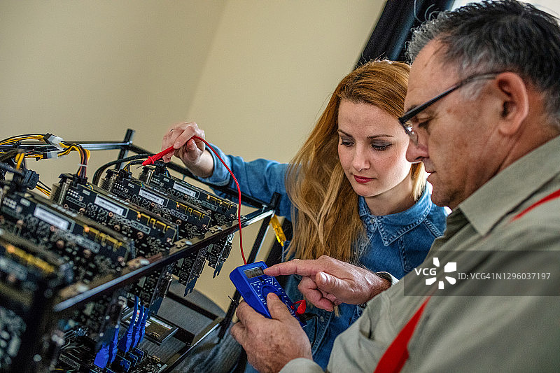 程序员调整加密货币挖矿设备至最佳运行设置图片素材