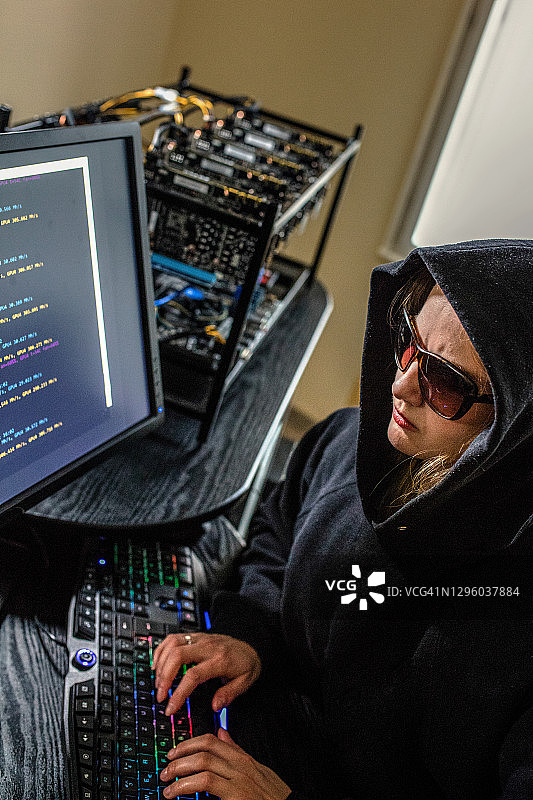 使用电脑进行加密货币挖掘的女黑客图片素材