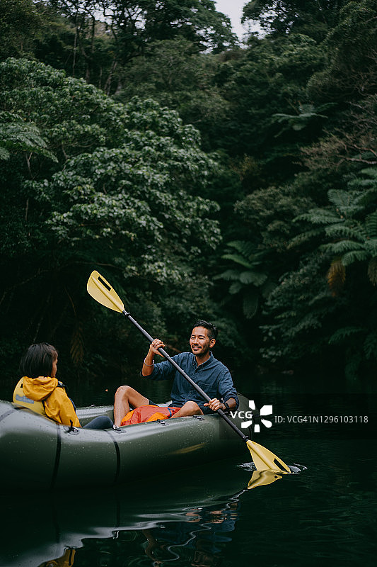 父子在冲绳丛林河流上划橡皮艇（日本）图片素材