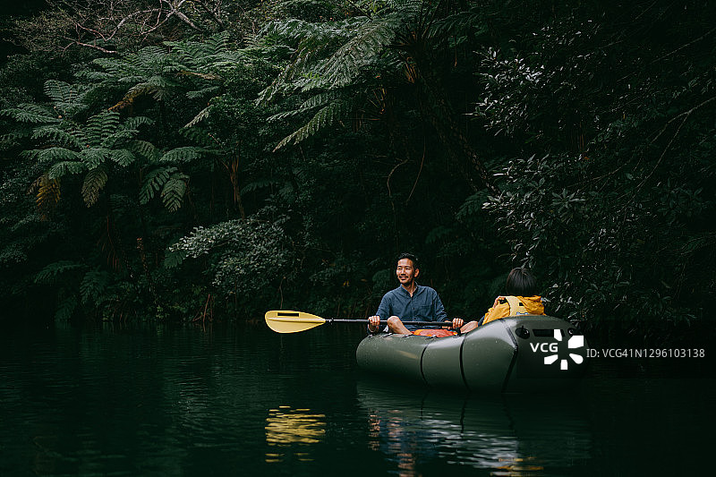 父亲与孩子在日本冲绳的丛林河流上享受皮划艇乐趣图片素材