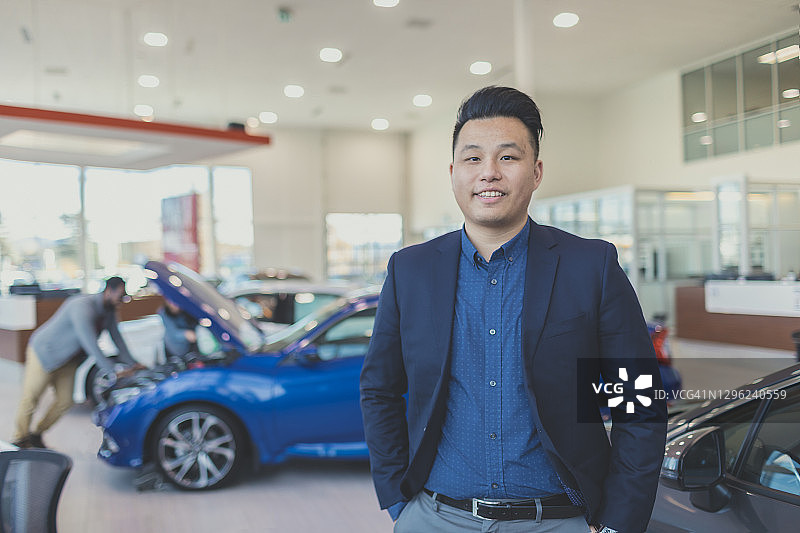 穿着时尚的汽车销售员在经销店的肖像图片素材