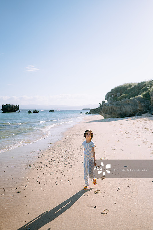 走在中国日本海滩上的快乐的年轻混血女孩图片素材