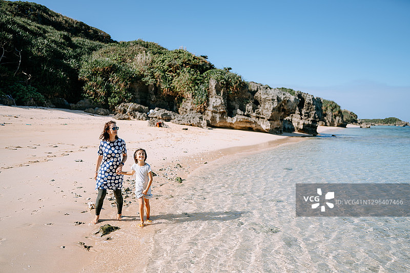 小女孩和母亲在日本海滩散步图片素材