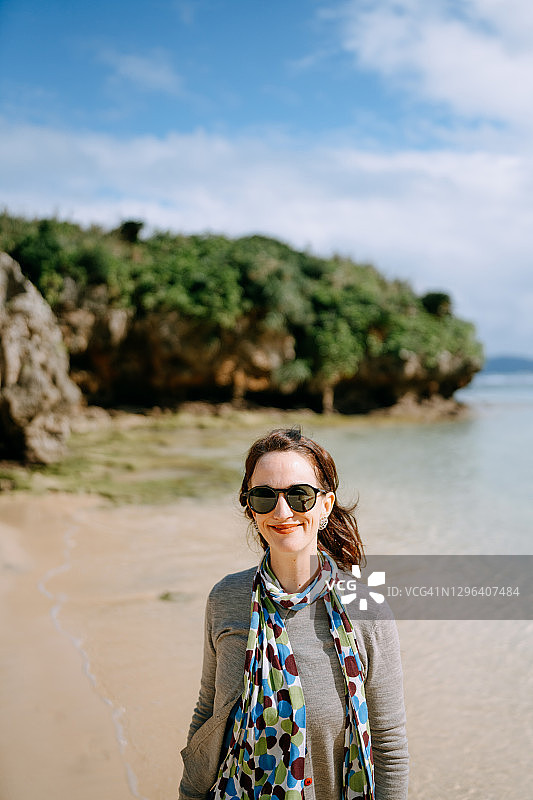 在海滩上对着镜头微笑的白人妇女图片素材