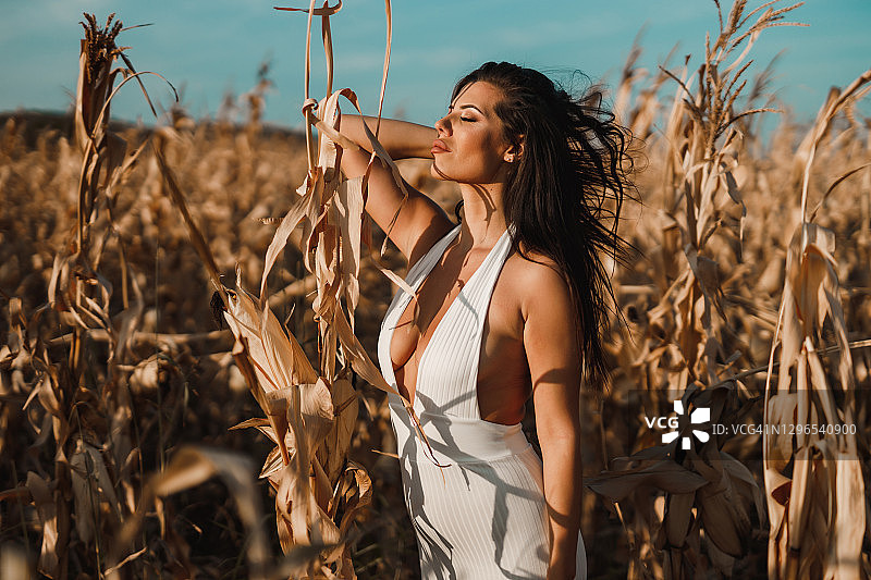 在农田里穿着白色连衣裙的漂亮女人图片素材