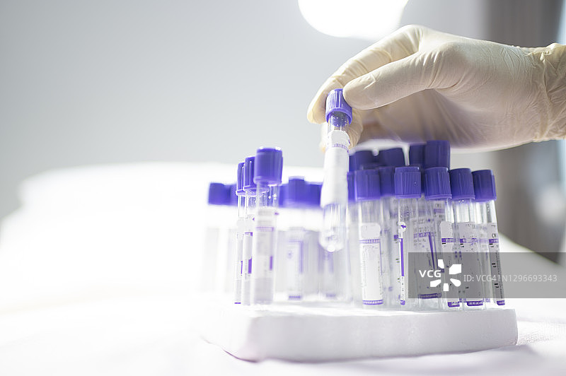 亚裔中国女护士戴着防护手套在实验室检查和整理新冠病毒测试套件图片素材