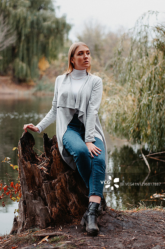 坐在河边以秋叶为背景的女孩图片素材