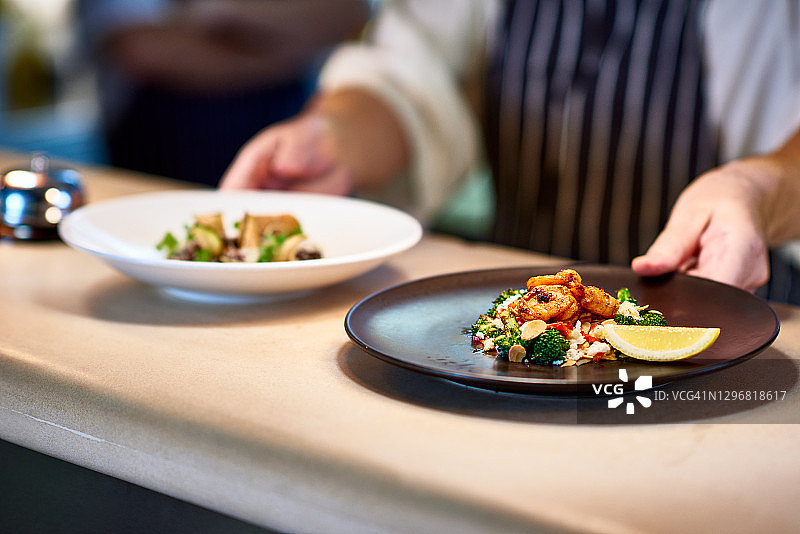 厨师将准备好的食物放在柜台上图片素材