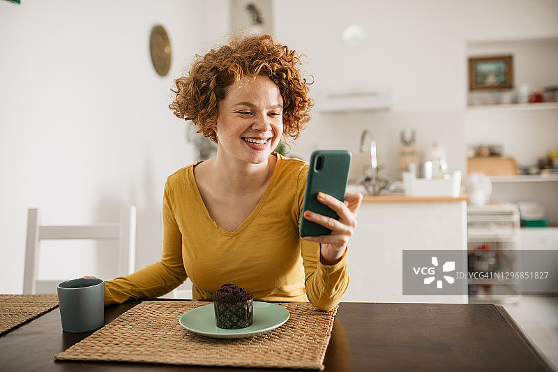 快乐的年轻白人女性使用智能手机图片素材