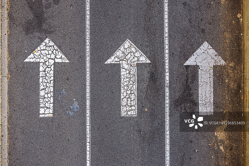 俯视沥青路面上的白色箭头图片素材