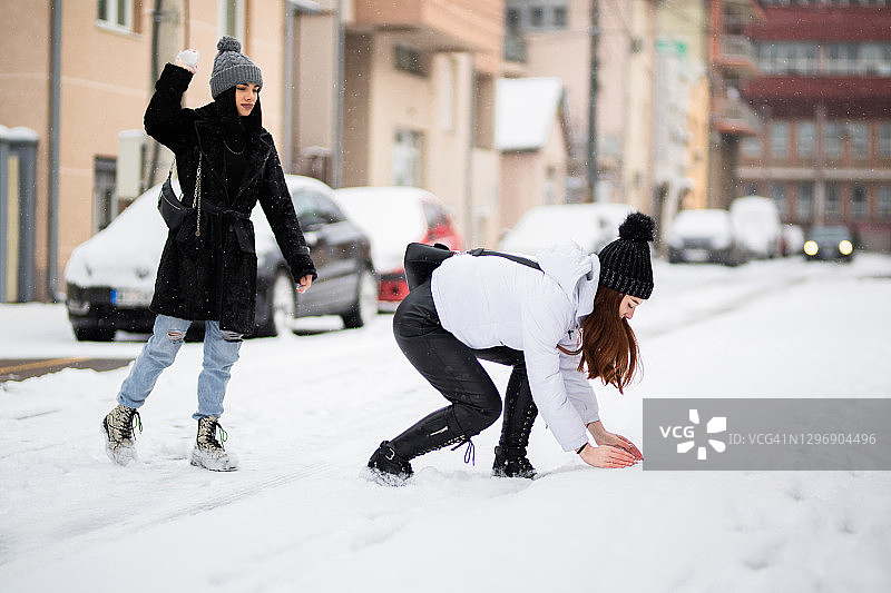 少女好友们享受打雪仗的乐趣图片素材