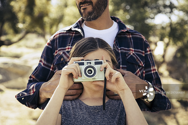 小女孩和父亲用数码相机拍照图片素材