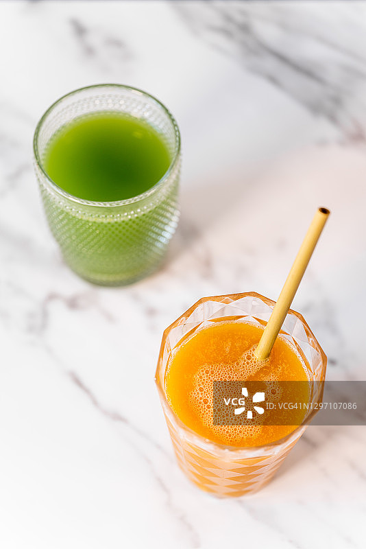 大理石桌上两杯橙汁与绿色果汁图片素材