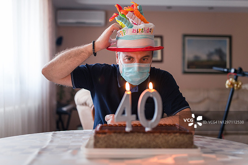 戴防护面具和滑稽帽子的男人庆祝40岁生日图片素材