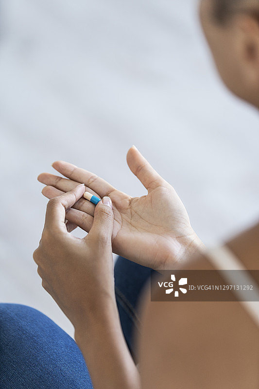 手握药片的年轻女人图片素材