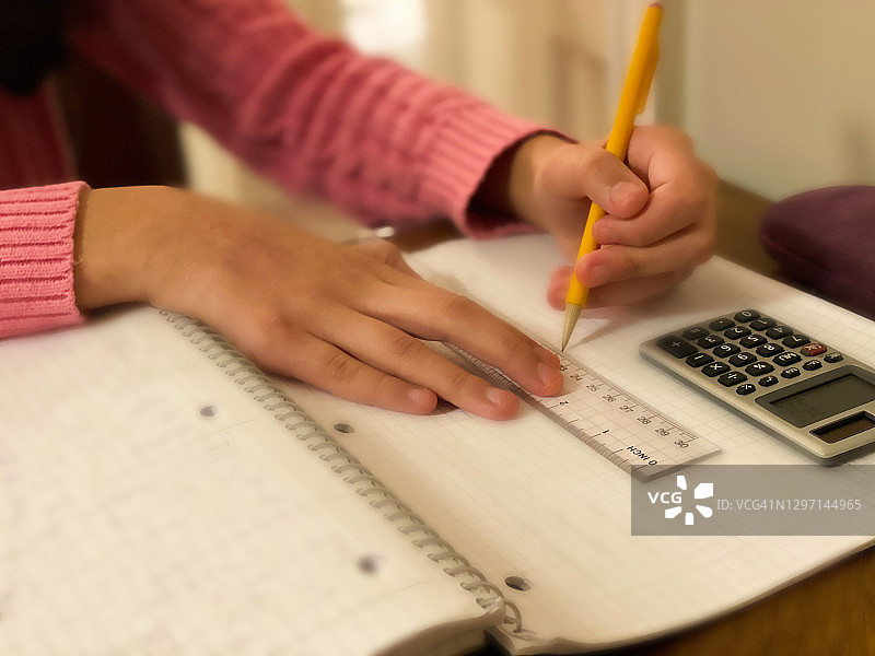用尺子和计算器做作业的混血少女图片素材
