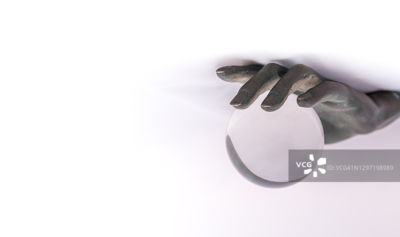 青铜手握着一个玻璃球，即将掉落图片素材