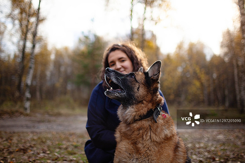 年轻女人拥抱着她的德国牧羊犬图片素材
