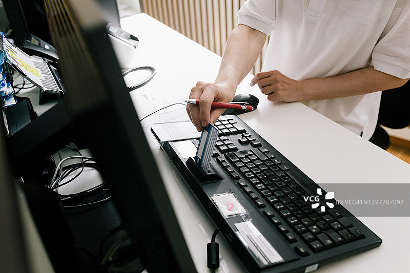 接待员接收患者的医疗保险卡图片素材