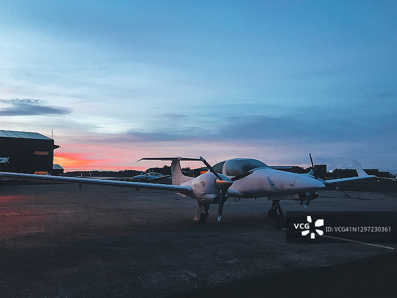 日出时停放的双引擎螺旋桨飞机图片素材