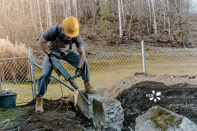 男人使用手提钻破碎混凝土块图片素材