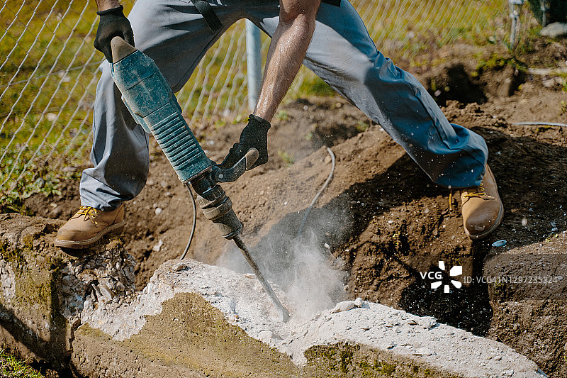 工人用风镐钻混凝土块的下半身图片素材
