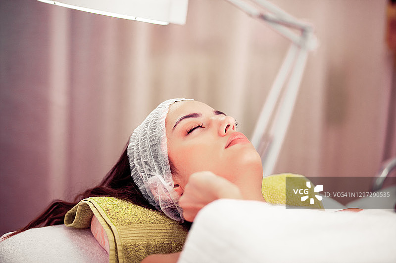 年轻女人在美容院接受面部护理图片素材