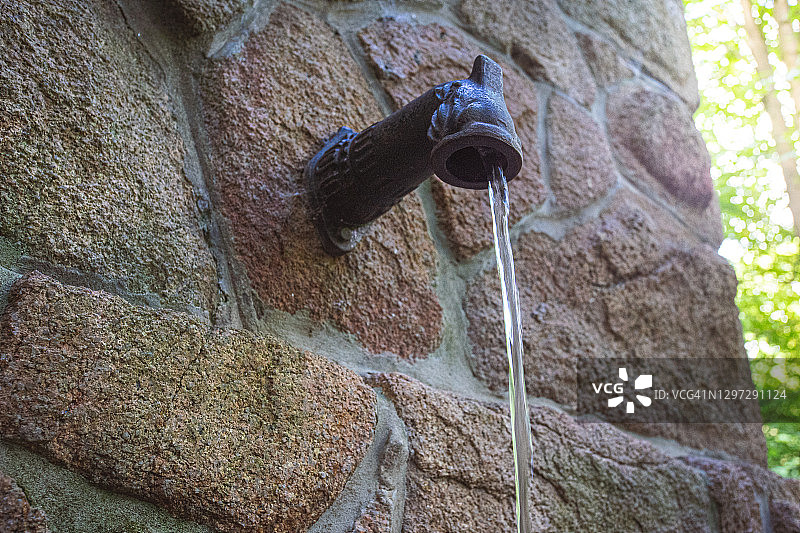 砖墙处水龙头流水特写图片素材