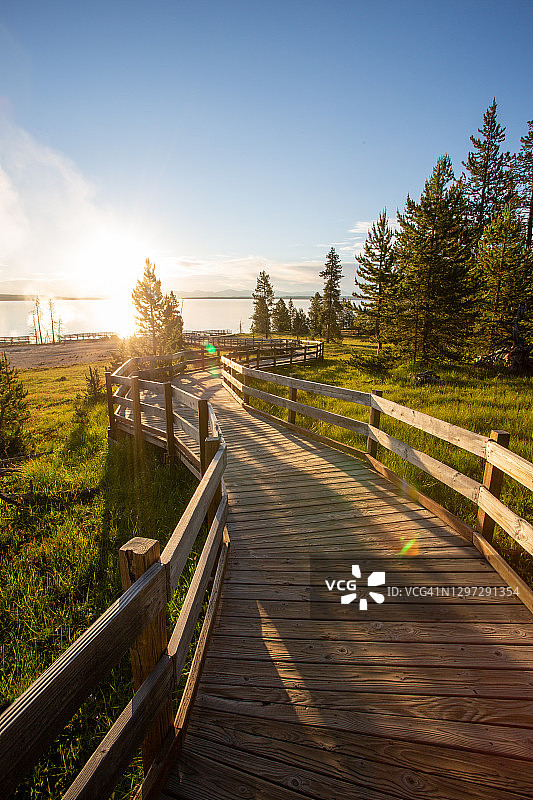 日出时分，木板路和间歇泉冒着蒸汽的主观视角图片素材