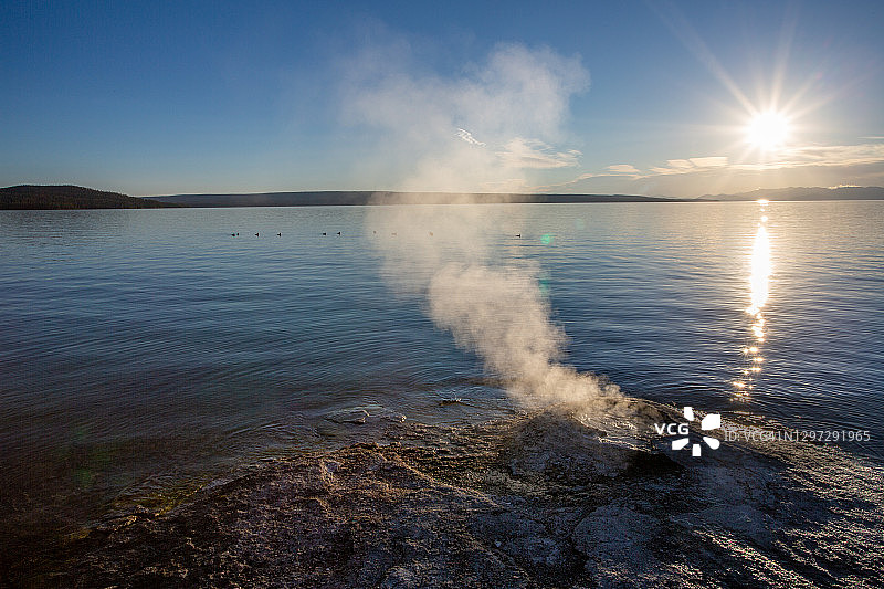 冉冉升起的太阳逆光照亮了黄石湖大锥间歇泉图片素材