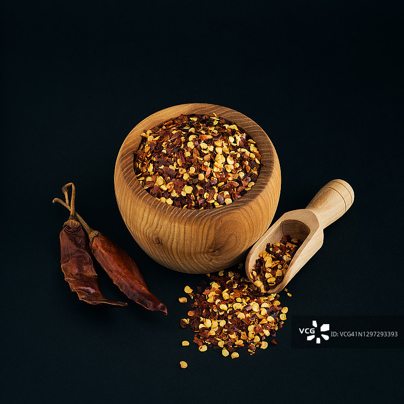 木碗中压碎的红色卡宴辣椒、辣椒干和辣椒籽图片素材