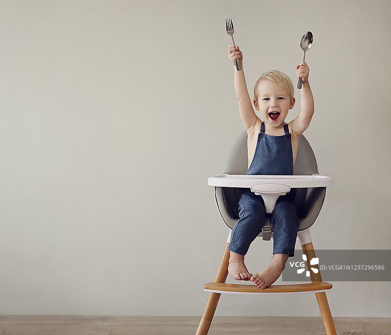 坐在高脚椅上的微笑男孩图片素材
