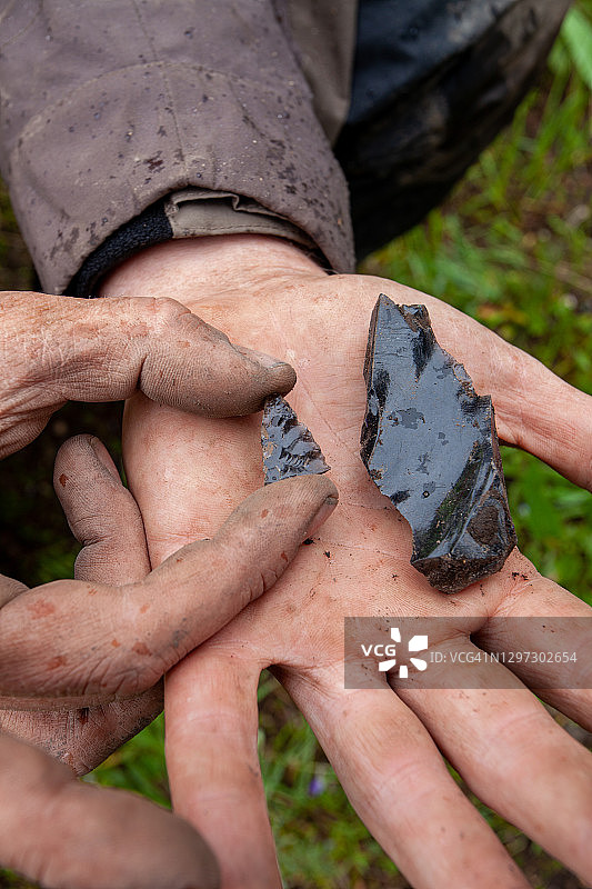 男人手持古代黑曜石箭头碎片特写图片素材