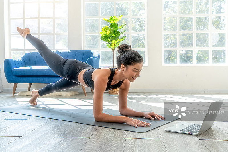 健身女性在客厅平板支撑在线学习图片素材