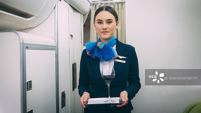 空姐在飞机上提供红酒服务图片素材