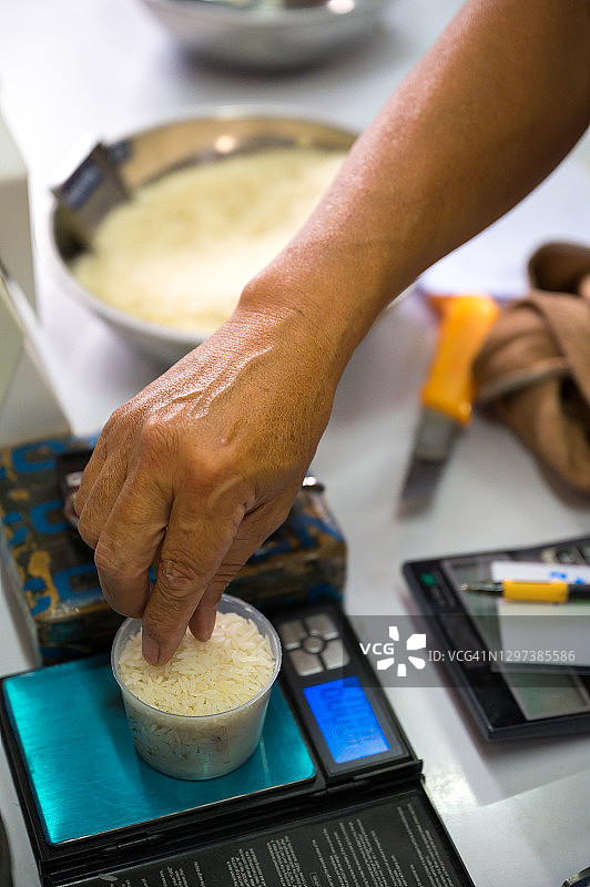 双手称量白米，进行质量控制图片素材
