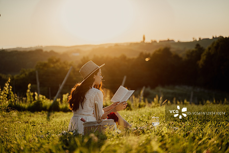 年轻女人在公园里读书图片素材